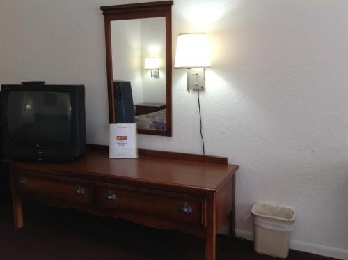 a television sitting on a dresser in a hotel room at Budget Host Hempstead Inn Brookhollow/Energy Corridor in Houston