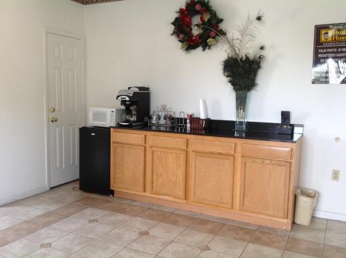 a kitchen with a counter with a microwave and a refrigerator at Budget Host Hempstead Inn Brookhollow/Energy Corridor in Houston
