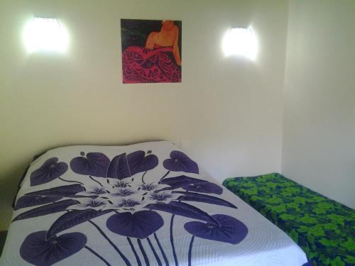 sypialnia z łóżkiem i obrazem na ścianie w obiekcie Fare Manutea w Nuku Hiva