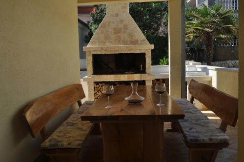 a wooden table with wine glasses and a fireplace at Apartments Olive i Lavender in Mandre