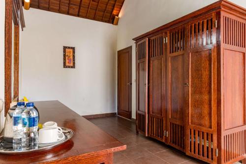 a room with a wooden cabinet and a table at Villa Taman di Blayu by Nagisa Bali in Tabanan