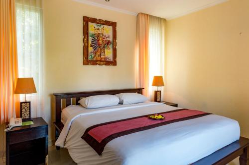 a bedroom with a large white bed with flowers on it at Villa Taman di Blayu by Nagisa Bali in Tabanan