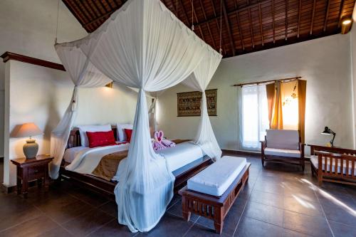a bedroom with a bed with mosquito netting at Villa Taman di Blayu by Nagisa Bali in Tabanan