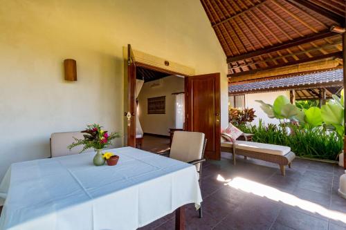 a dining room with a table with a blue table cloth at Villa Taman di Blayu by Nagisa Bali in Tabanan
