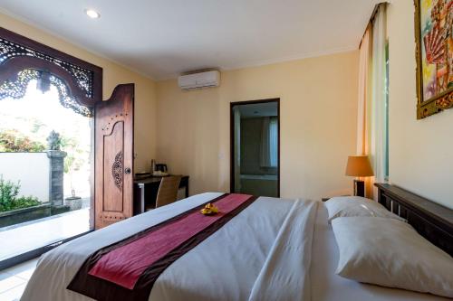 a bedroom with a bed and a large window at Villa Taman di Blayu by Nagisa Bali in Tabanan