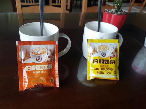 two coffee mugs sitting on a table with a bag of coffee beans at Ming Yang B&B in Fenchihu