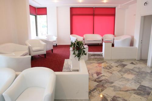 a waiting room with white chairs and red walls at Scala Nuova Annex in Cesme
