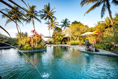 una piscina en un complejo con un perro en el medio en Villa Taman di Blayu by Nagisa Bali, en Tabanan