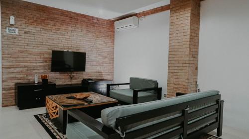 a living room with a couch and a table and a tv at Seaview Beach Resort in Jepara