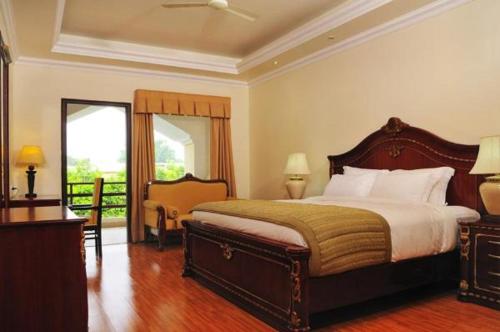a bedroom with a bed and a desk and a window at Le Roi Corbett in Garjia