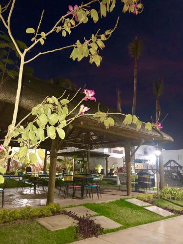 a wooden pavilion with tables and chairs at night at CASA EN PRIVADA FRENTE A LA PLAYA CON ALBERCA! in Mazatlán