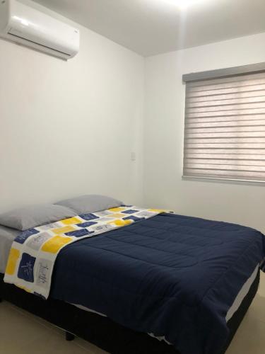 a bedroom with a bed with a blue and yellow blanket at CASA EN PRIVADA FRENTE A LA PLAYA CON ALBERCA! in Mazatlán