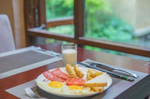 a plate of breakfast food and a glass of milk at Arro Khampa By Zinc Journey Shangri-la in Shangri-La