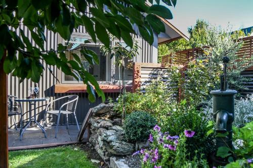 a patio with a table and chairs in a garden at Clyde on Naylor in Clyde