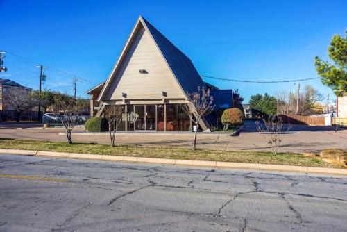 a church with a black roof on a street at Motel 6-Arlington, TX - UTA in Arlington