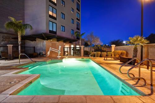 una piscina por la noche con un hotel en Hyatt Place Phoenix Gilbert, en Gilbert