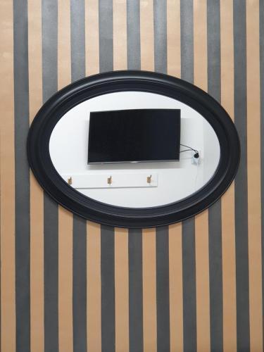 a black and white mirror on a wall at Archies Bunker Affordable Accommodation in Napier