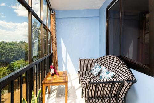 a chair sitting on a balcony with a table at Mrimba Palm Hotel in Arusha
