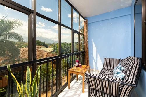 a balcony with a table and chairs and a view at Mrimba Palm Hotel in Arusha