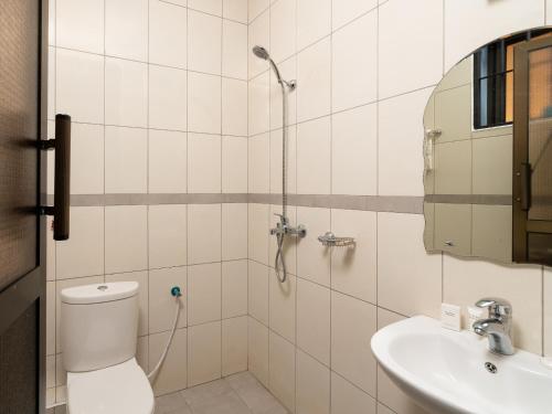 a bathroom with a shower and a toilet and a sink at Mrimba Palm Hotel in Arusha