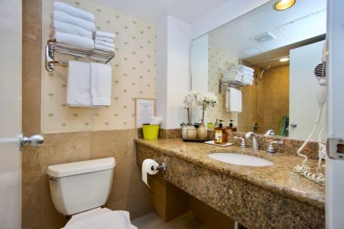 a bathroom with a sink and a toilet and a mirror at Palms Waikiki #412 in Honolulu