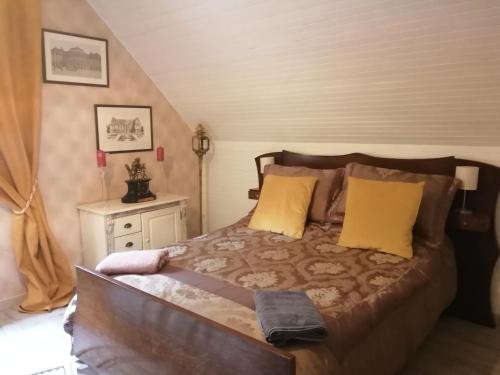 1 dormitorio con 1 cama grande con almohadas amarillas en Angelina et ses animaux, en Pléchâtel
