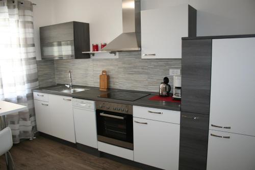 una cucina con armadi bianchi e piano cottura di Apartma Center a Bovec