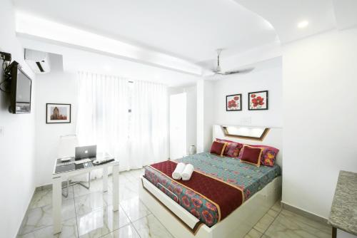 a bedroom with a bed and a desk and a laptop at Rahul Residency in Mangalore