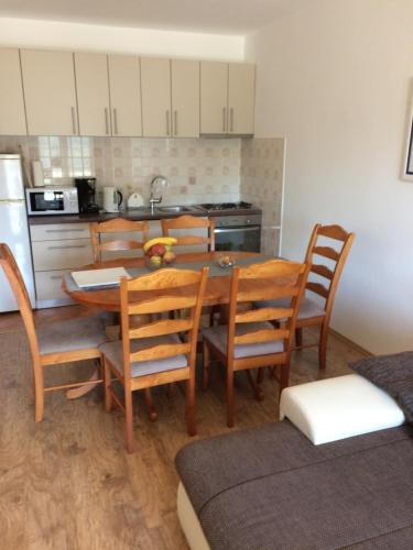 a kitchen with a table and chairs and a refrigerator at Apartments ORCHIDEA 1 in Dubrovnik