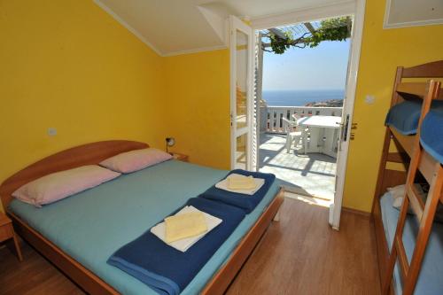 a bedroom with a bed and a balcony with the ocean at Guest House Banana in Dubrovnik