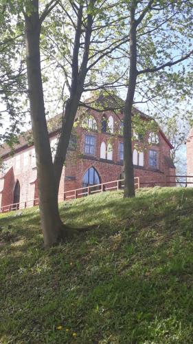 two trees in front of a brick building at Landhaus am Schaalsee in Zarrentin