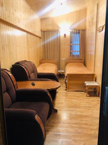 ein Zimmer mit drei Betten, einem Tisch und Stühlen in der Unterkunft HarMar Budget Hotel in the Centre in Goris