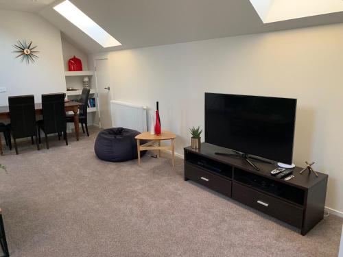 uma sala de estar com uma televisão de ecrã plano num centro de entretenimento em 112 Rural View em Cambridge