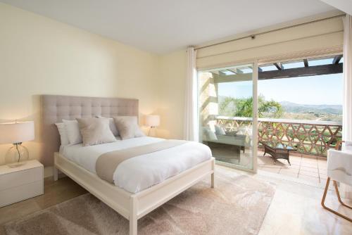 una camera con un grande letto e un balcone di Luxury townhouse La Cala Golf Resort (Golf, Beach, Nature and Amazing views) a La Cala de Mijas