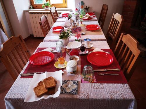a long table with red plates and food on it at Antico Borgo di Torri in Sovicille