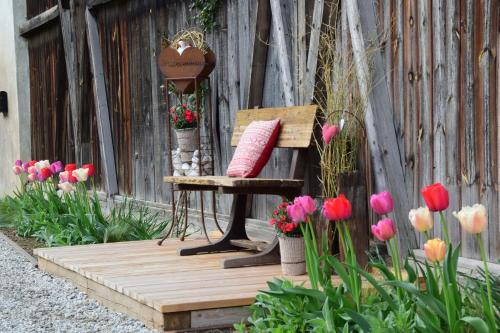 a wooden porch with a bench and flowers at Appartements Mayrhof in Bressanone