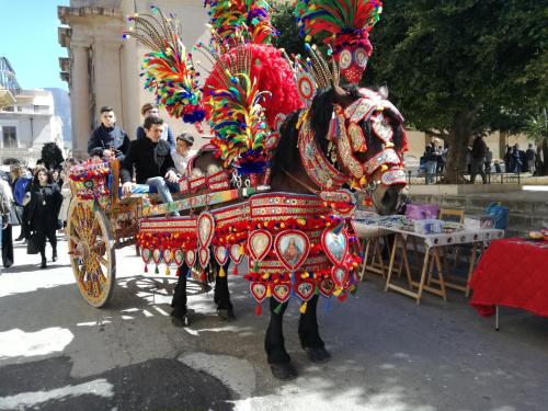a horse pulling a carriage in a parade at Terra Sinus Holiday House in Terrasini