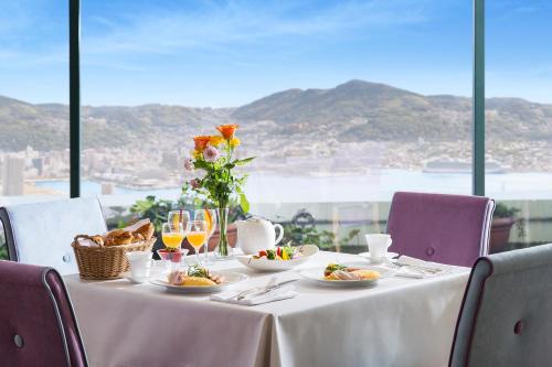 a table with plates of food and a view of the ocean at Luke Plaza Hotel in Nagasaki