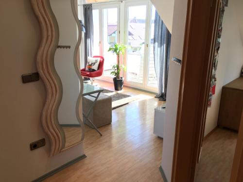 a mirror in a living room with a red chair at Kays Home in Bad Wörishofen