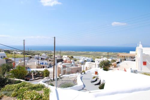 a view of a town with the ocean in the background at White Grape Suites in Oia
