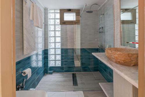 La salle de bains est pourvue d'un lavabo et d'une douche en verre. dans l'établissement Agios Titos Luxury Home, à Héraklion