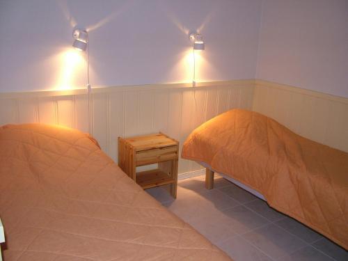 アカスロンポロにあるYllästar 305 Apartmentのベッド2台 壁に照明が付く部屋