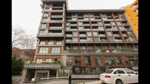 a tall building with a car parked in front of it at CTS Elysium Residence Taksim in Istanbul