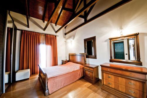 Un dormitorio con una cama, una cómoda y un espejo. en Villa Theano, en Agios Nikolaos