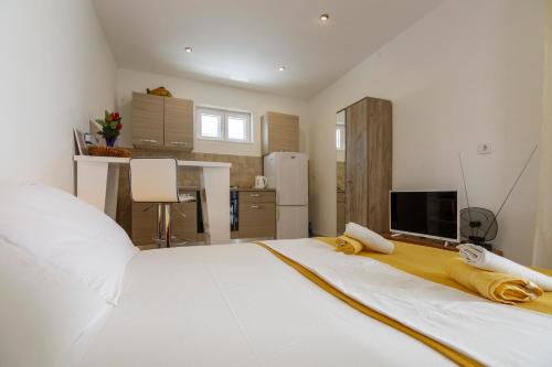 a large white bed in a room with a kitchen at ComeIssa in Komiža