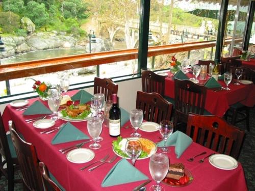 a table with a red table cloth and wine glasses at The Gateway Restaurant & Lodge in Three Rivers