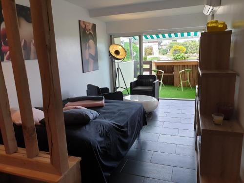 - une chambre avec un lit et un salon dans l'établissement Studio Naturiste P.Nature 6, au Cap d'Agde