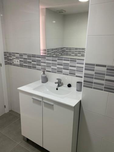 a white bathroom with a sink and a mirror at Amate con encanto in Seville