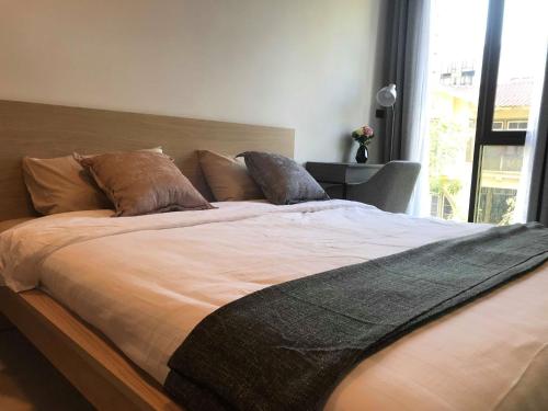 a large bed with brown pillows in a bedroom at CBD Asoke/Nana/Ploenchit +2 mins to Terminal 21 in Bangkok