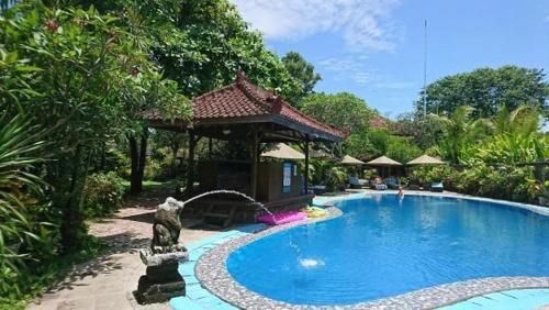 een zwembad met een tuinhuisje in de tuin bij Gazebo Beach Hotel in Sanur